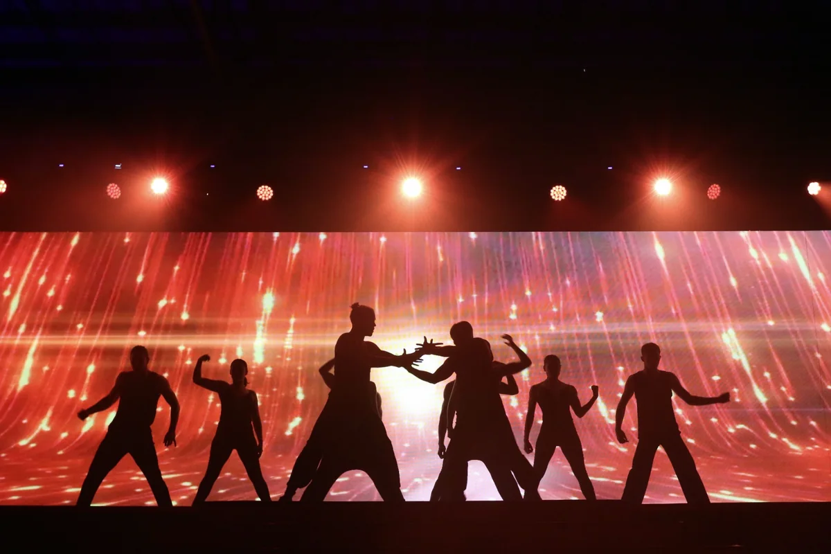 Silhouetted dancers on a stage